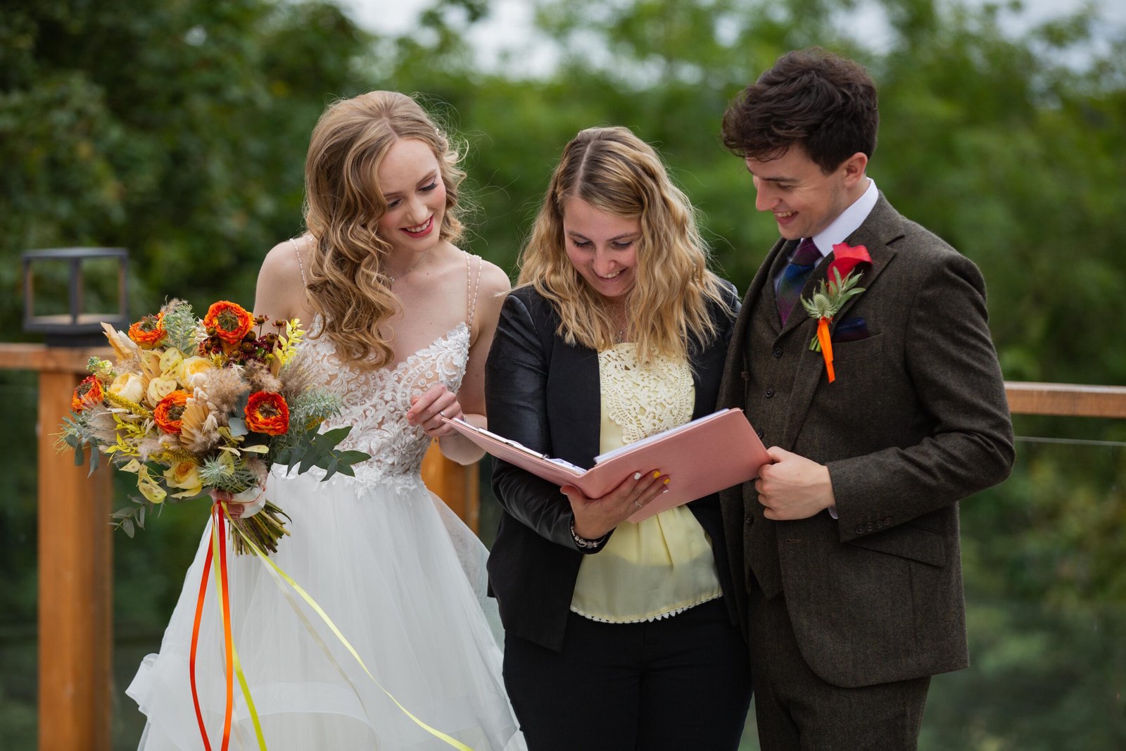 Wedding planner in Scotland holding a clipboard with the bride and the groom